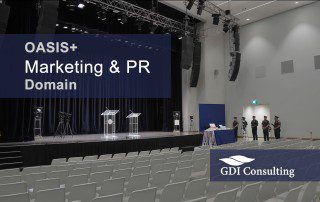 Government auditorium set for a marketing and PR domain briefing, with stage, podiums, cameras, and seating.